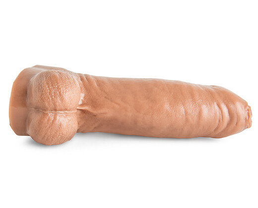 The skin toned chorizo n eggs dildo placed horizontally on the side with a white background on a white surface