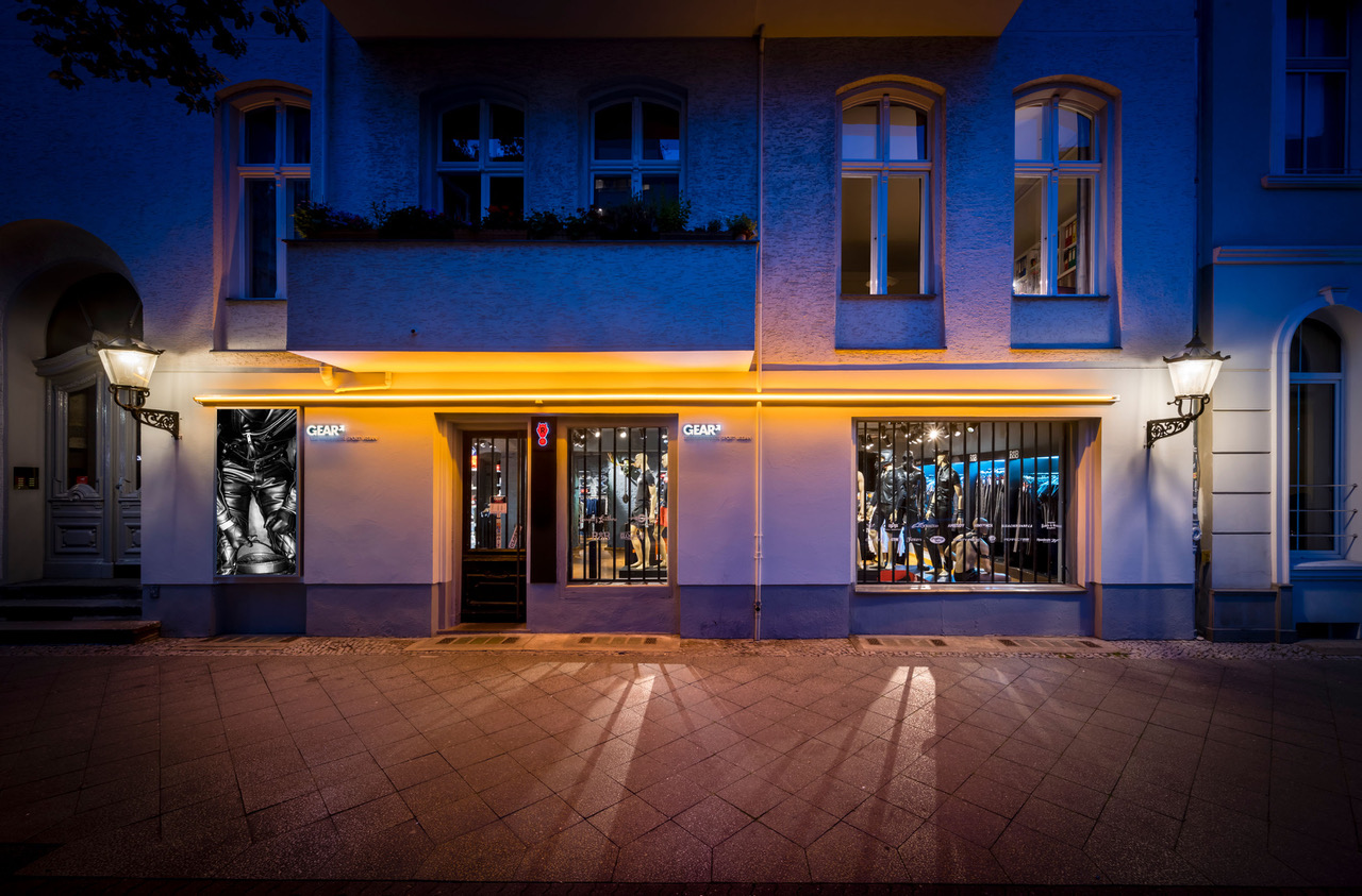 A building with a neon sign on the front, glowing brightly at night.