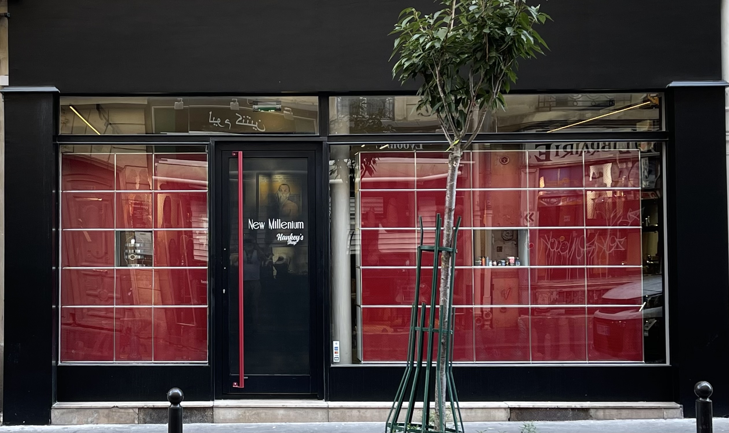 Red and black storefront with tree in front, creating a cozy atmosphere.