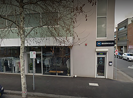 A building with a car parked in front on a street.