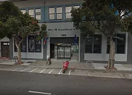 A red motorcycle parked in front of a building.